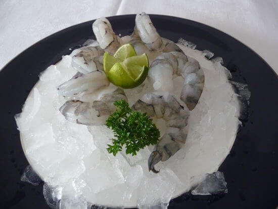 rohe Garnelen auf Eis mit Limette und Petersilie