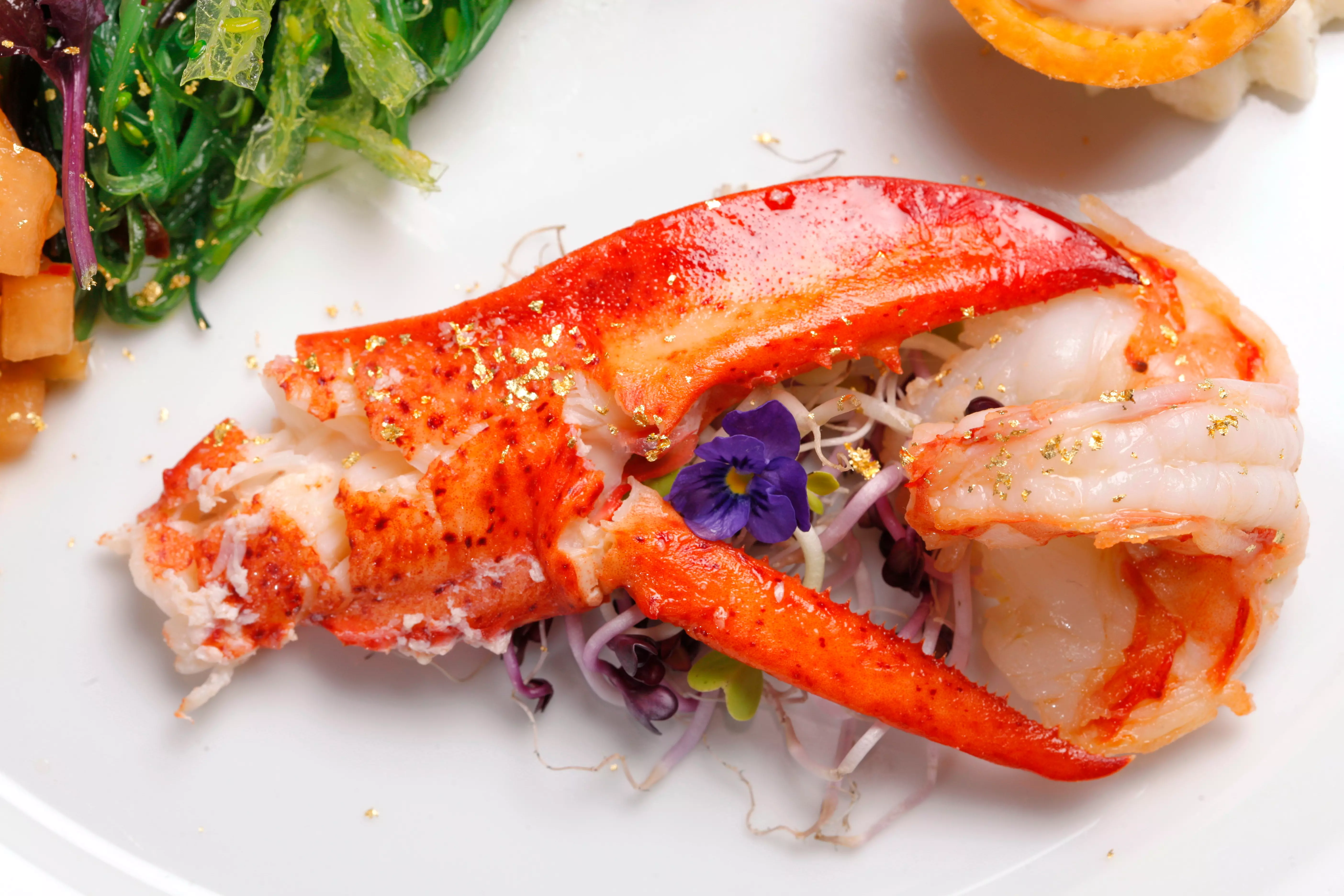 gegarte Hummerklaue mit essbaren Goldflocken auf Salat