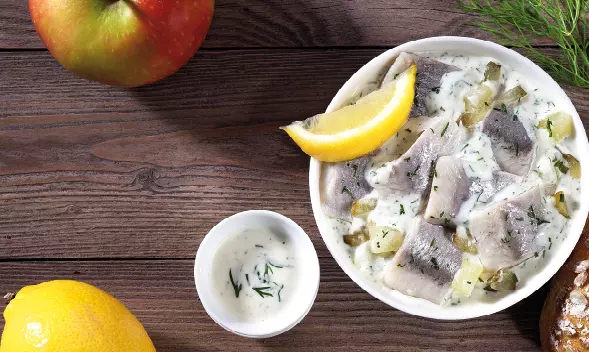 Heringsfiletstücke in Sahnesoße mit Zitrone in Schüssel