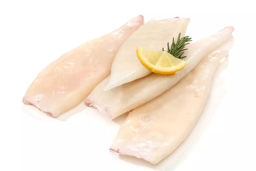 rohe Tintenfisch Tuben mit Zitronenscheibe und Rosmarin
