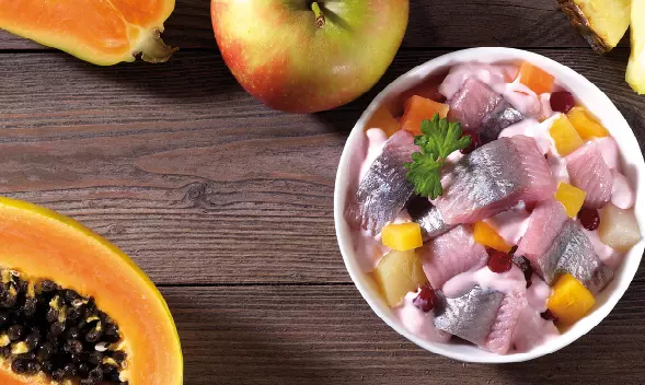 Heringssalat mit Obstwürfeln in Sahnesoße in Schüssel