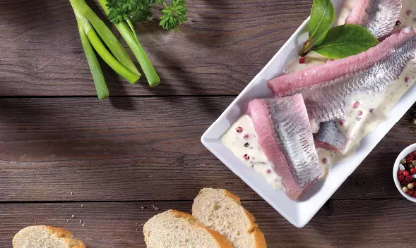 Heringsfilets in Sahnesauce mit Brot und Kräutern