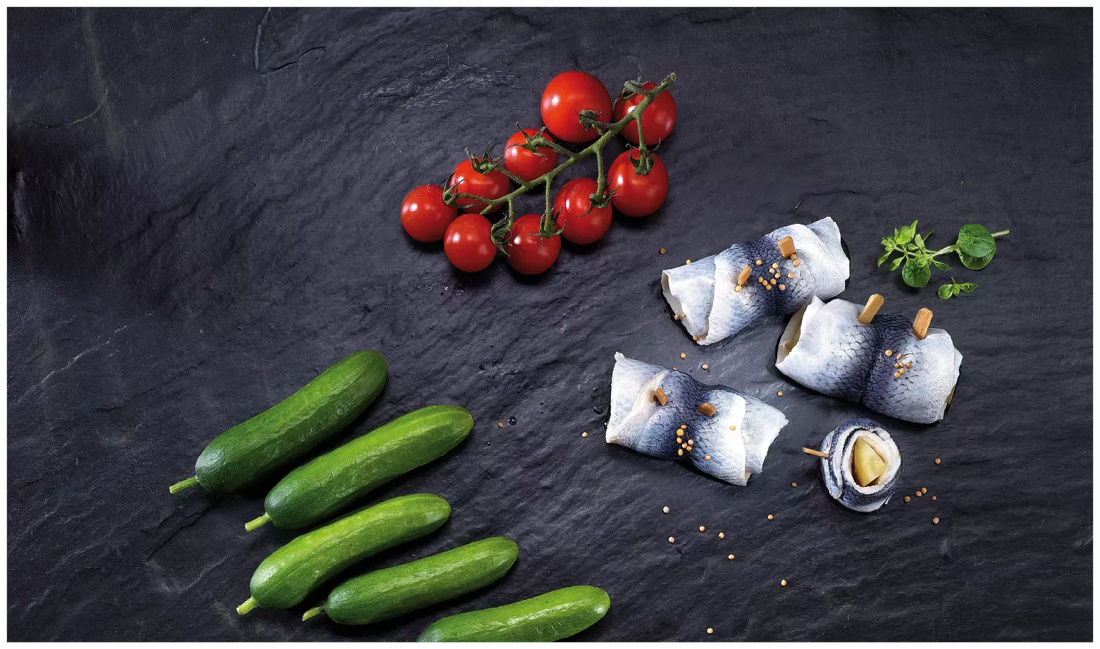 Matjes-Rollmops, Gurken und Tomaten auf Schieferplatte