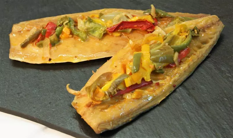Makrelenfilets mit buntem Gemüse belegt auf Schieferplatte