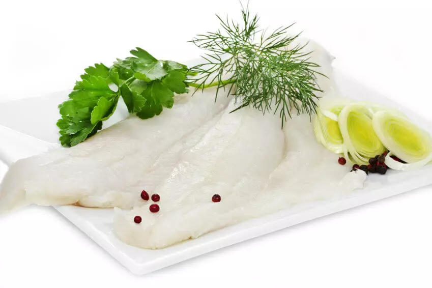 Rohes Seelachsfilet mit Kräutern und Lauch auf Teller