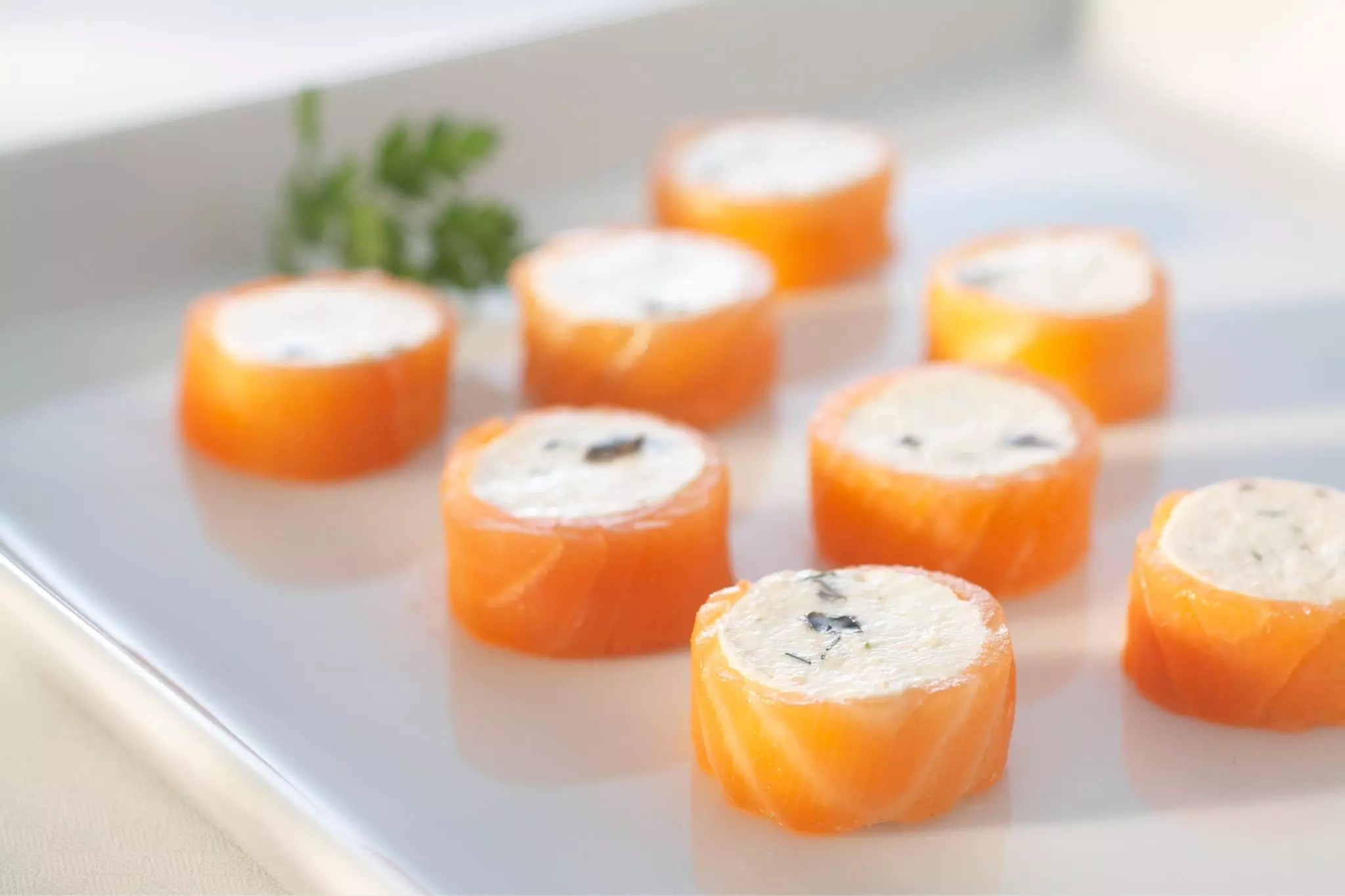 Lachsrouladen mit Frischkäsefüllung auf Teller angerichtet