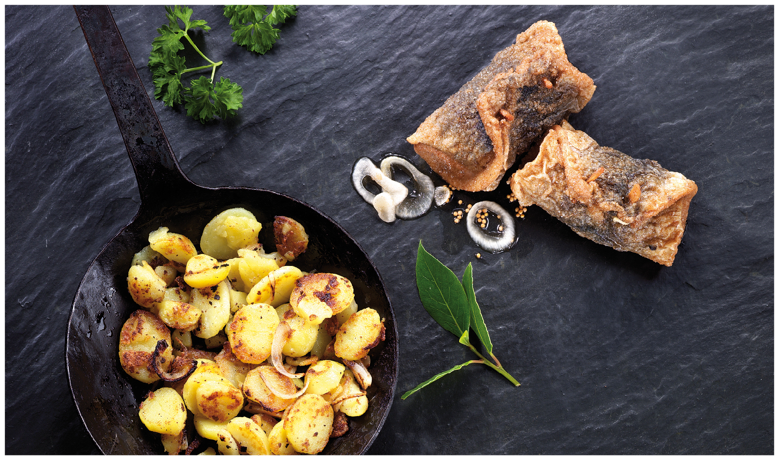 Gebackener Fisch mit Bratkartoffeln und Kräutern Ein Teller mit knusprig gebackenem Fisch und Bratkartoffeln, garniert mit frischen Kräutern und Gewürzen